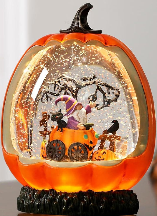 Orange pumpkin-shaped snow globe with swirling glitter and Halloween figurine scene