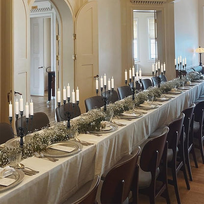 Black metal candelabra taper candle holders along a long banquet table