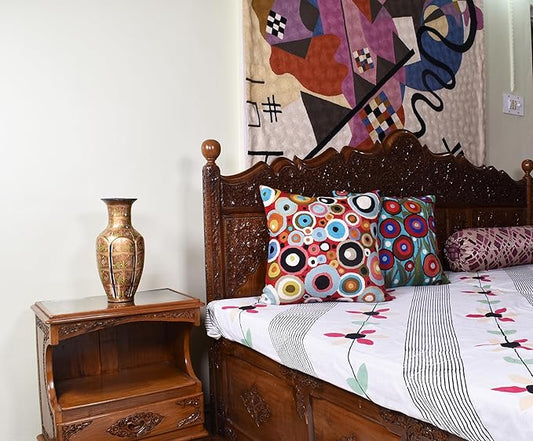 Multicolor circular-pattern pillow cover on bed with white bedding and chair decor