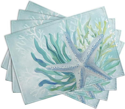 Set of teal blue ocean placemats with starfish and seaweed print, shown stacked
