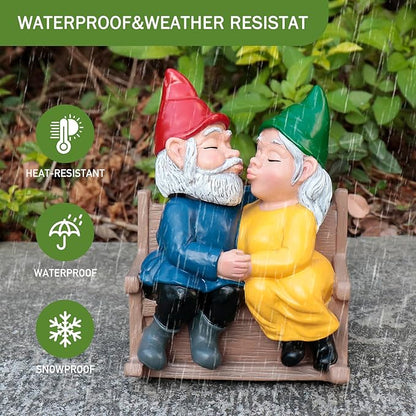 Garden gnome couple rocking chair statue on stone, kissing, red and green hats, blue and yellow