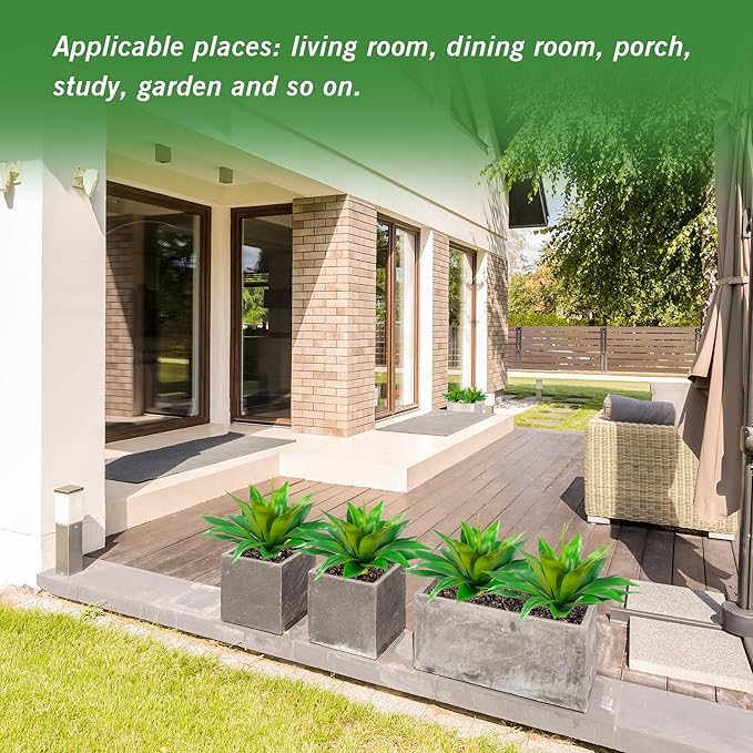 Green faux agave plants arranged along a stone patio garden border
