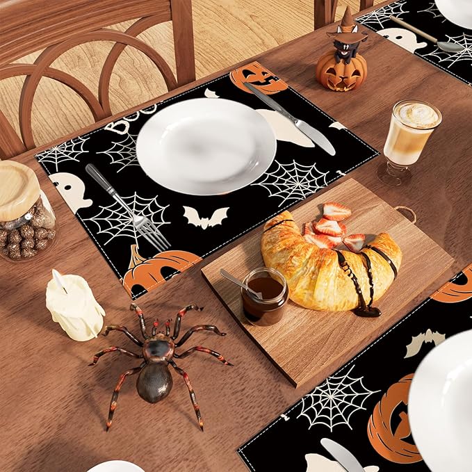 Halloween placemat set: black mat with white ghosts, orange pumpkins, bats, and spiderwebs.
