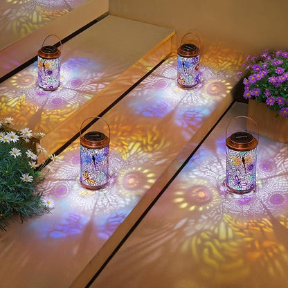 Glowing set of solar dragonfly lanterns on patio, multicolor stained-glass patterns