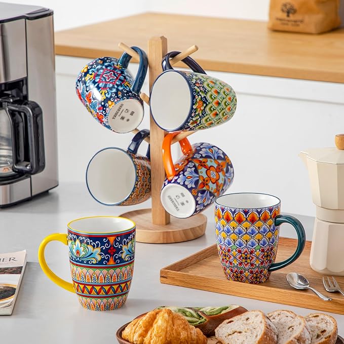 Assorted boho ceramic coffee mugs with handles displayed on wooden stands, colorful patterns