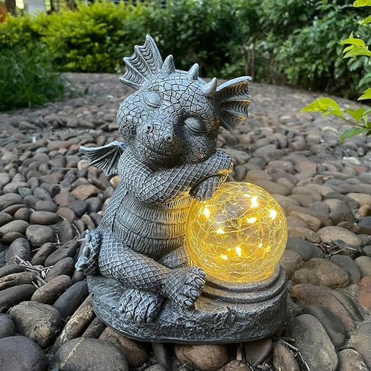 Gray dragon resin figurine sitting and holding a glowing glass orb for outdoor decor