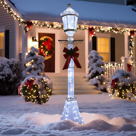 Pre-lit Christmas lamp post decoration with glowing lantern and red bow on a silver pole