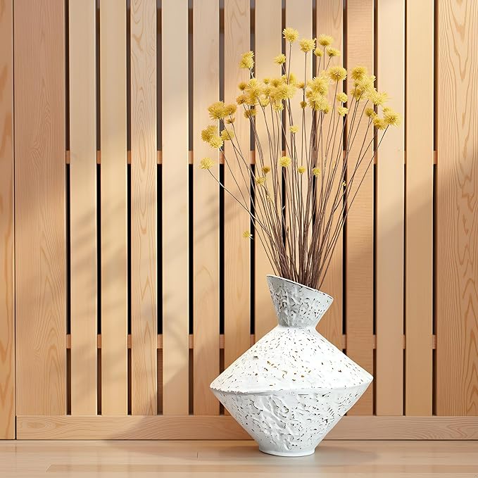 White hammered cast iron vase with angled neck, speckled finish, standing on wooden surface