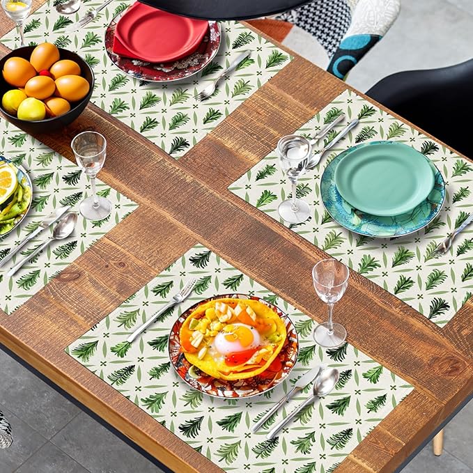 Four pine tree placemats arranged in an X layout, sage green print on light fabric.