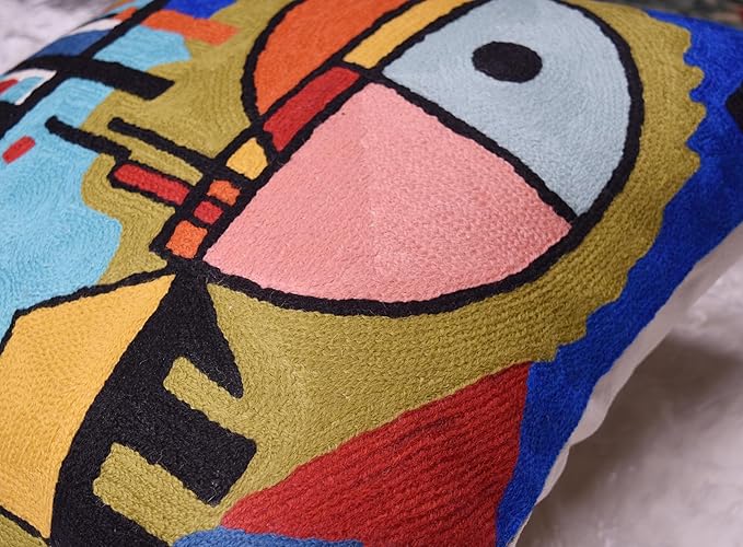 Blue abstract pillow cover detail with face motif, yellow blocks and red accents