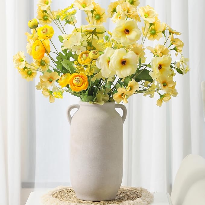 White rustic ceramic vase with side handles, holding yellow and cream flowers