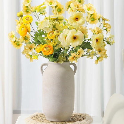 White rustic ceramic vase with side handles, holding yellow and cream flowers