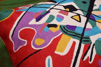 Red abstract pillow cover close-up corner with colorful blocks, dots, and black lines