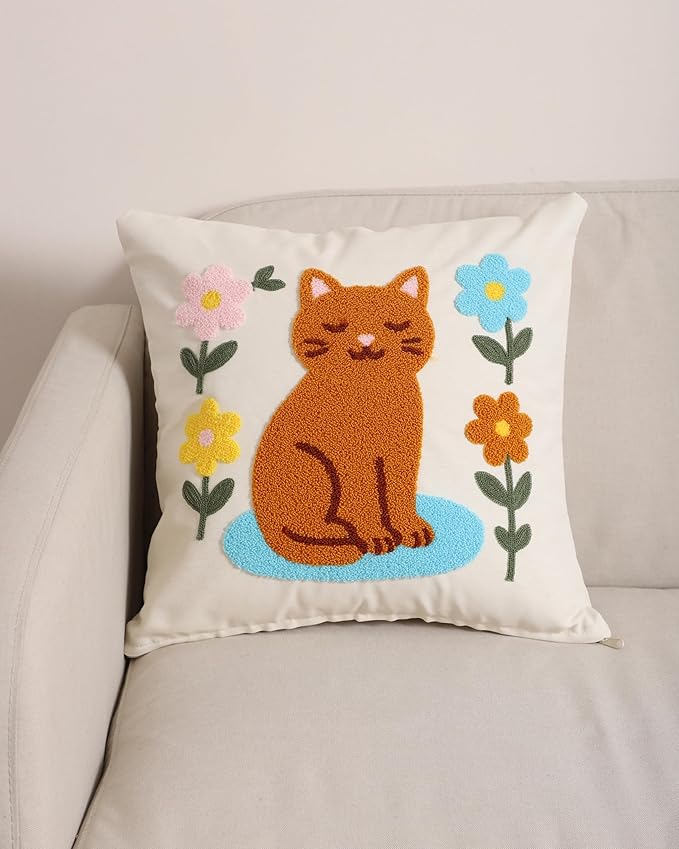 Cream pillow cover featuring an embroidered orange cat sitting on a blue base