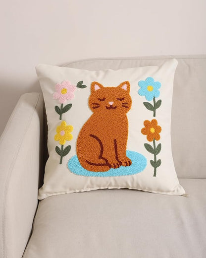 Cream pillow cover featuring an embroidered orange cat sitting on a blue base
