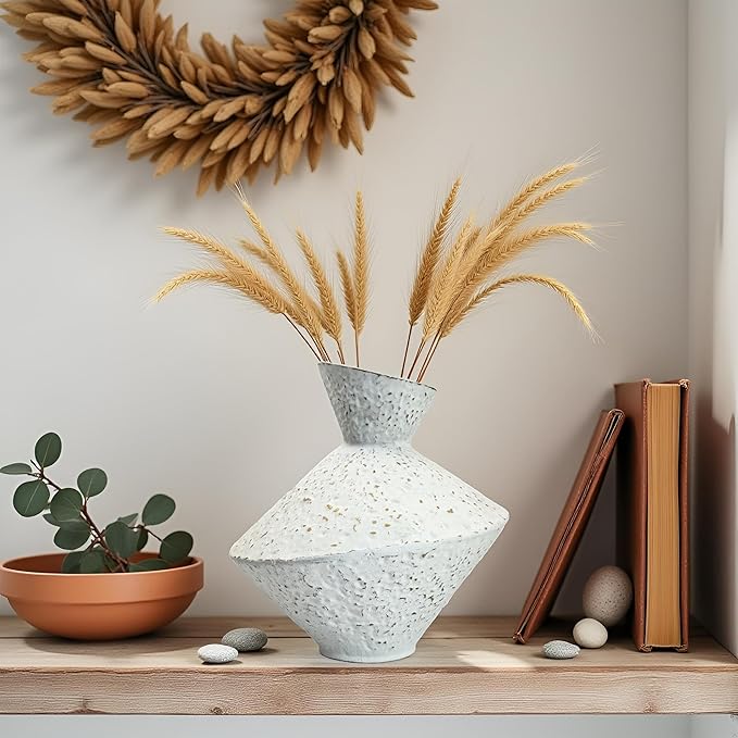 White hammered cast iron vase with angled neck, speckled texture, holding dried stems