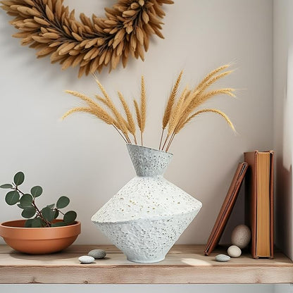 White hammered cast iron vase with angled neck, speckled texture, holding dried stems