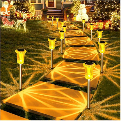 Outdoor solar lantern stake lights illuminating a walkway with warm amber light
