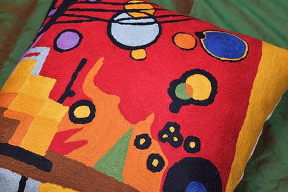 Red abstract embroidered pillow cover with yellow, green, and blue circular accents