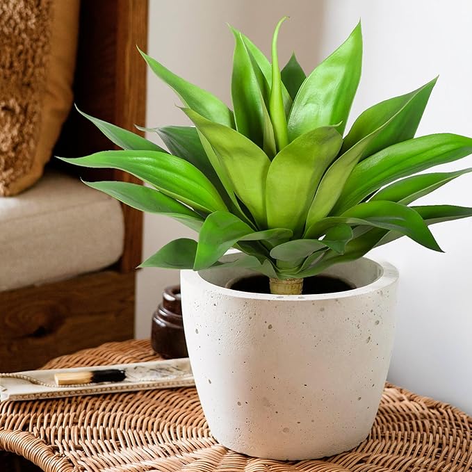 Green faux agave plant in speckled white pot