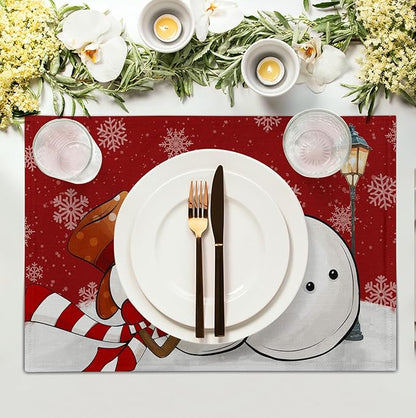 Red Christmas snowman placemat with snowflake pattern under a dinner plate and cutlery