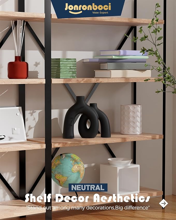 Matte black ceramic hug vase on a shelf, two joined donut-like shapes with openings