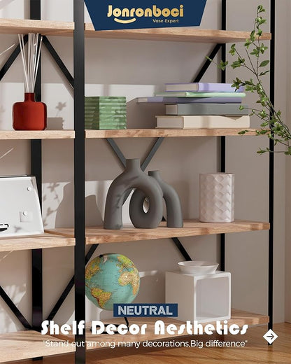 Dark gray matte ceramic conjoined vase sculpture with oval donut cutout on bookcase