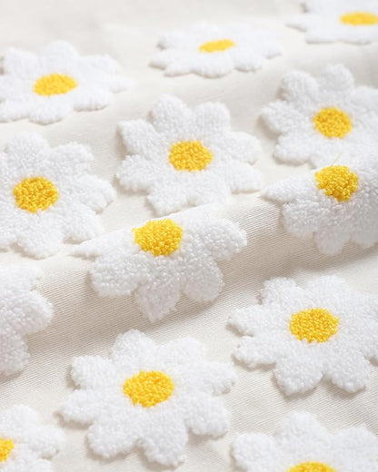 Textured daisy pattern on cream pillow cover: white blooms with yellow centers