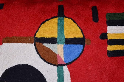 Red wool throw pillow cover close-up of multicolor circle and striped rectangles