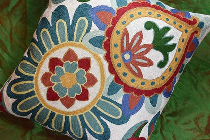 Embroidered floral pillow cover with two circular designs in teal, blue, red, and green on cream