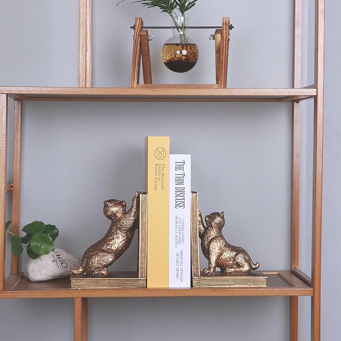 Antique gold cat resin bookends pair on a shelf, cats facing outward