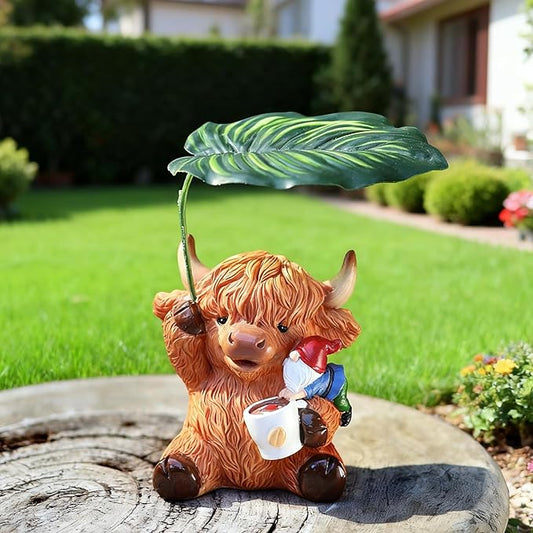 Garden yard ornament: orange Highland cow figurine holding a mug under a green leaf parasol.