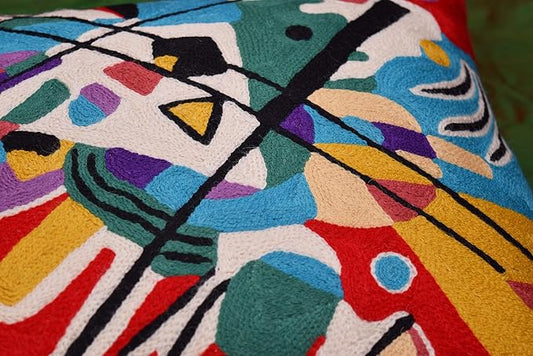 Red abstract pillow cover close-up with blue, teal, purple, and black line pattern