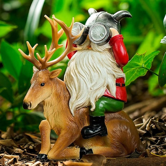 Resin garden gnome statue sitting on brown deer with antlers and solar lantern light
