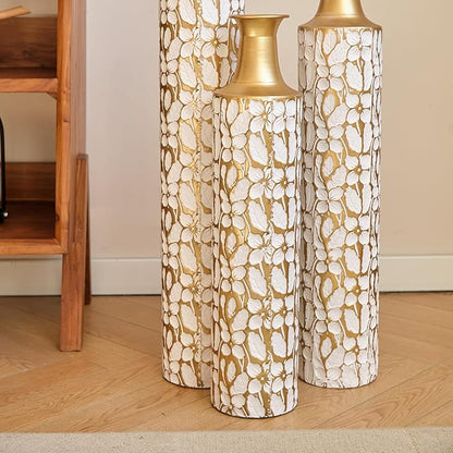 Three antique white and gold twig-pattern metal floor vases, varied heights