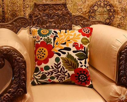Floral bird pillow cover on a decorative leather chair with ornate detailing.