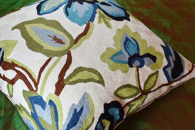 Floral pillow cover showing cream fabric with blue, green, and brown flower embroidery