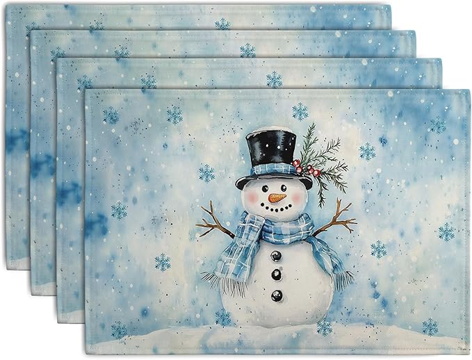 Set of 4 blue winter placemats with snowman and snowflake design, rectangular.