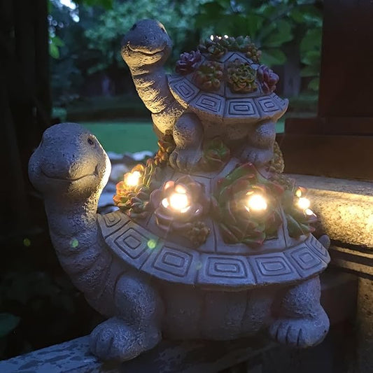 Turtle solar garden light figurine at night, warm LEDs glowing with flower details