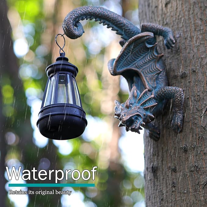 Outdoor dragon tree hugger statue beside black solar lantern, dark green-blue dragon wings