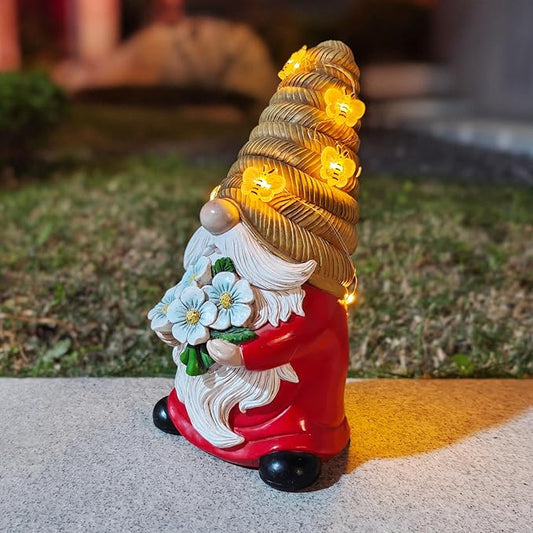 Bee-themed solar LED garden gnome statue, red coat and black boots, blue flower bouquet, lit