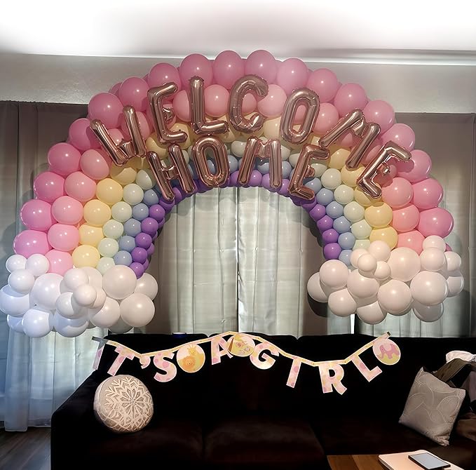 Rainbow balloon arch with pink, purple, yellow, blue, and white balloons and gold balloon letters