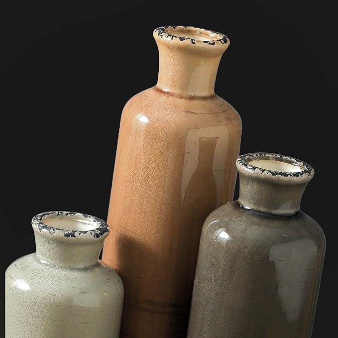 Three ceramic vases stacked together in terracotta, cream, and dark gray with rims