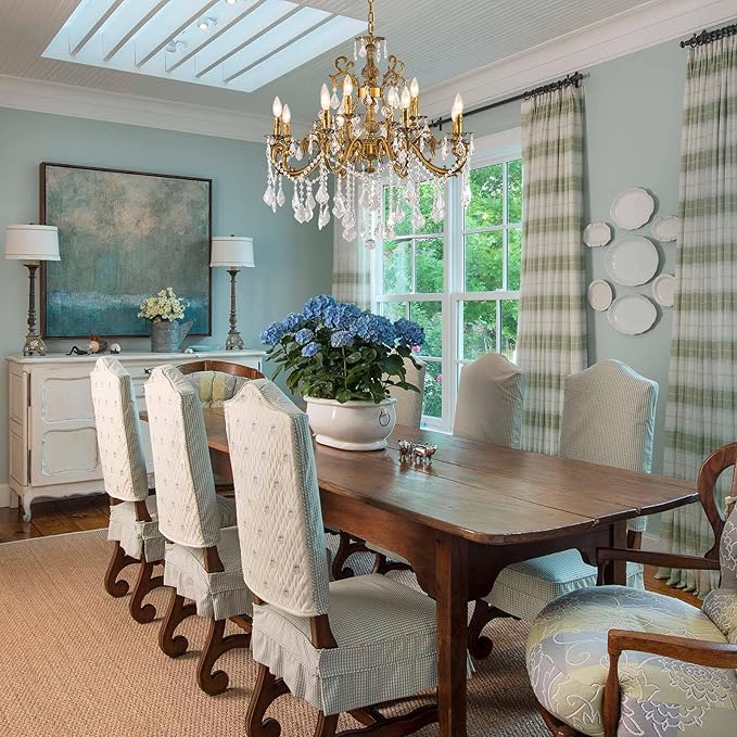 Gold crystal chandelier with candle-style bulbs and hanging crystal drop accents