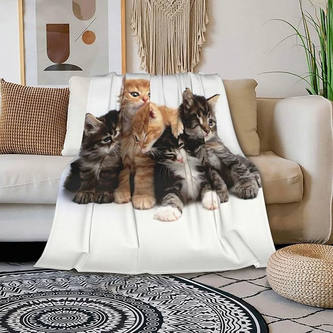 Cats throw blanket with five kittens print on white fleece draped over sofa