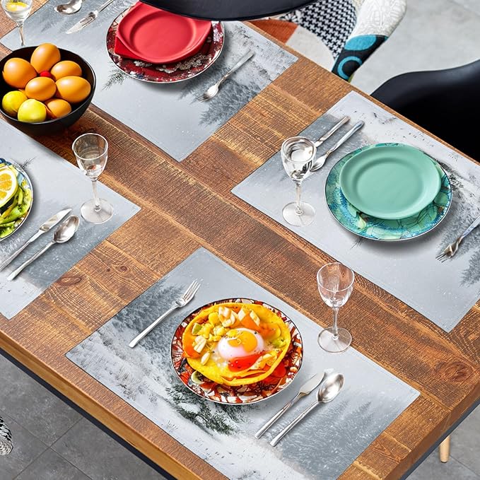 Set of winter placemats in use, pine tree snow prints on table with dishes.