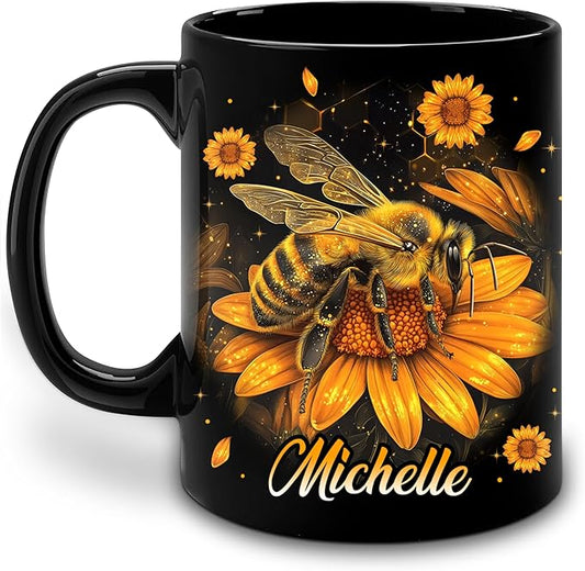 Black ceramic coffee mug with painted bee, sunflower flowers, and the name Michelle