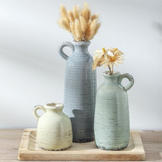 Set of three ceramic vases in blue-gray, mint green, and cream with side handles.