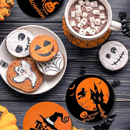 Halloween ceramic coasters with orange pumpkin and black artwork on a dark table