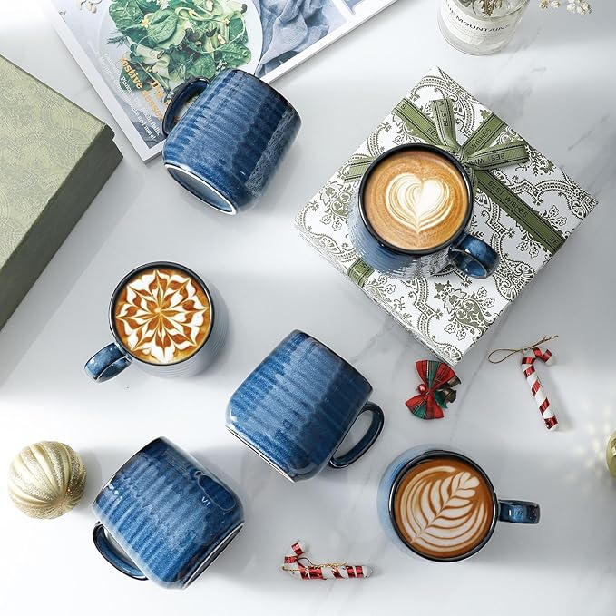 Blue ceramic espresso cups with handles and black interiors, on a tabletop
